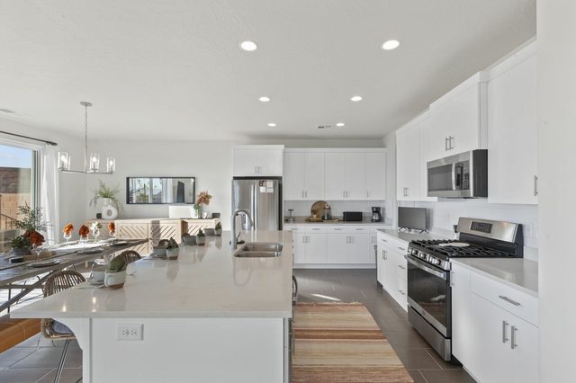 Kitchen with gas range, white cabinets and large island