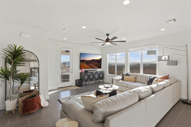 Living room sectional facing TV with desert views outside