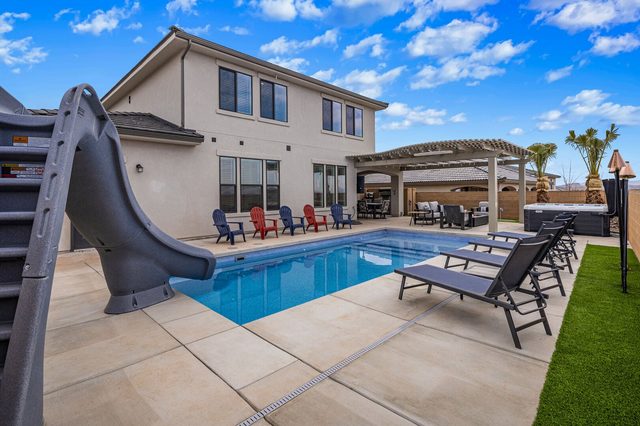 Private pool slide, loungers and pergola in the backyard
