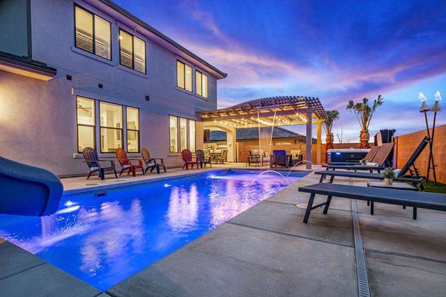 Private pool with slide and pergola lit at dusk at Paseos 1373