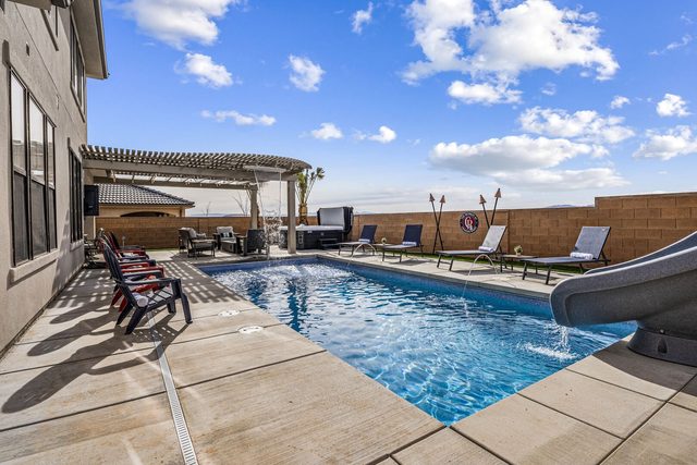Private pool with slide, loungers and Adirondack chairs at Paseos 1373