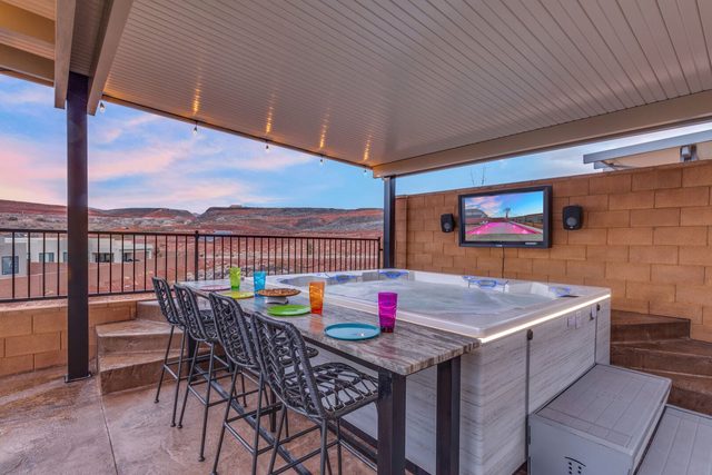 Covered hot tub with bar-height table and outdoor TV