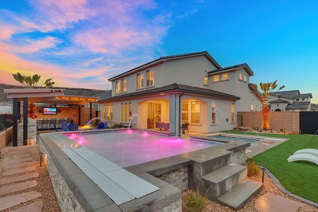 Raised private pool with lights and the rear of the house