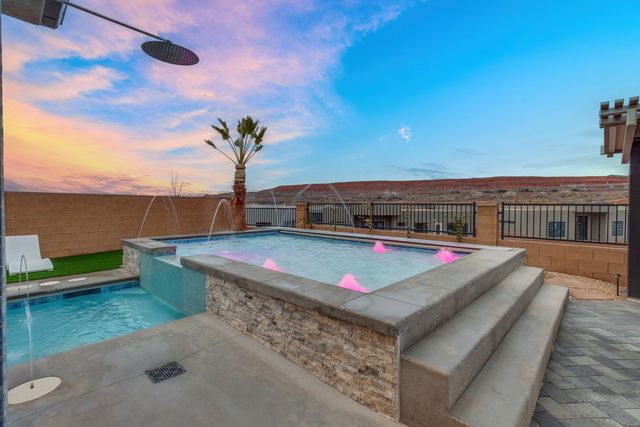 Raised shallow pool with steps and fountain jets at sunset