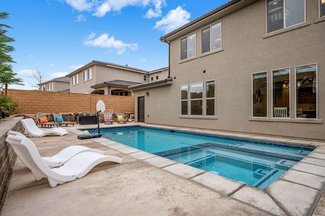 Private pool, loungers and basketball hoop in the backyard