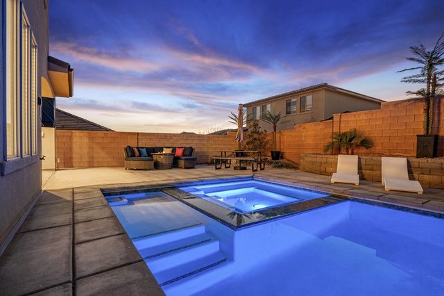 Pool steps and spa glowing blue in the evening