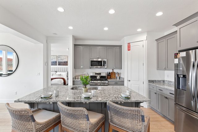 Kitchen island with woven bar stools and stainless appliances
