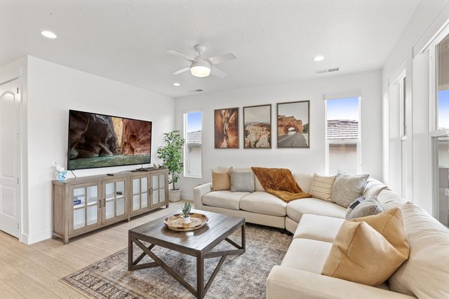 Living room with large wall-mounted TV and cream sectional sofa