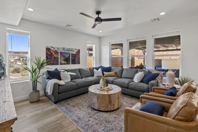 Living room with gray sectional, leather armchairs and round coffee table