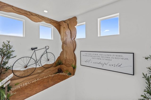 Upstairs landing with red rock wall mural and bicycle decor