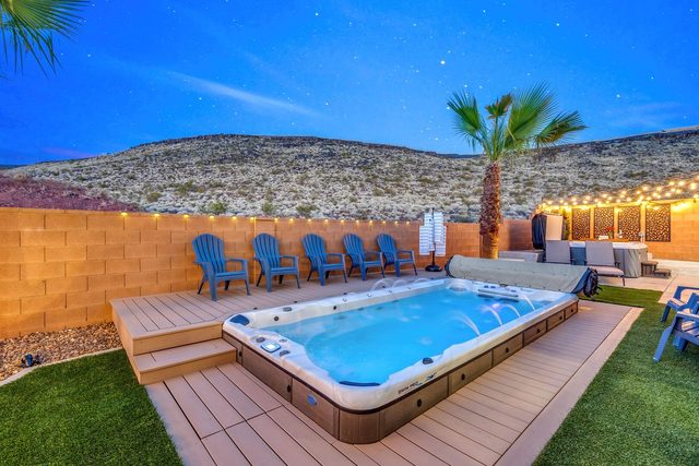 Private swim spa on a deck with Adirondack chairs and hillside