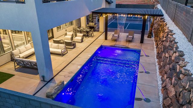 Private pool lit blue at night with pergola in home 5173 backyard