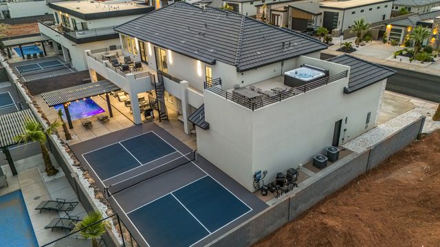 Aerial view of the house, rooftop hot tub, pool and pickleball court