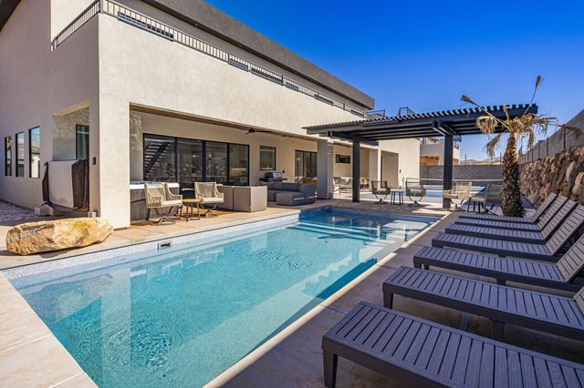 Private pool with row of loungers beside the house