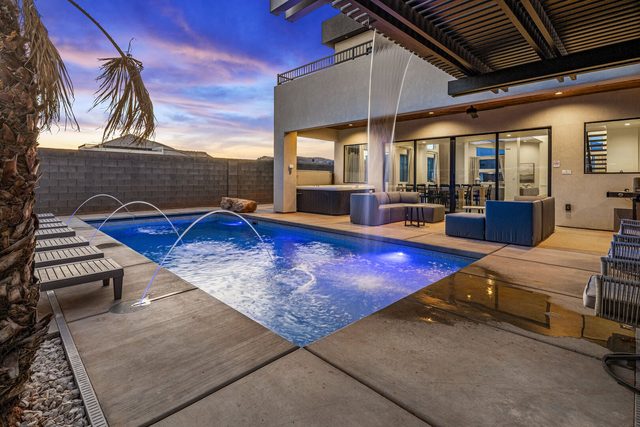 Private pool with deck jets and covered patio at dusk