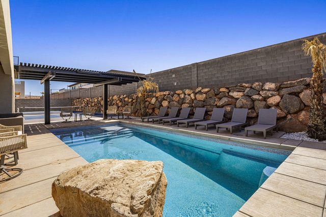 Private pool with boulder accent and loungers along the wall