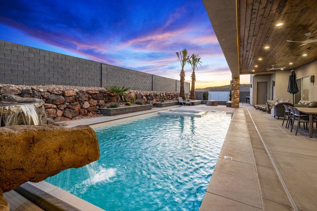 Private pool with rock waterfall beside the covered patio at Pecan Valley 5205