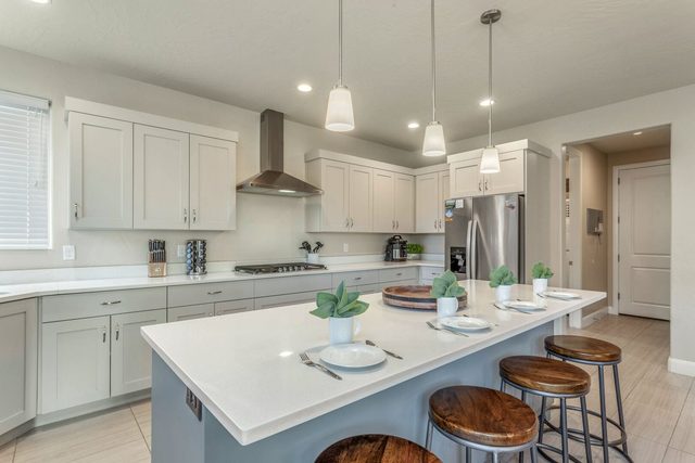 Unit 103 kitchen island with bar stools and gray cabinets