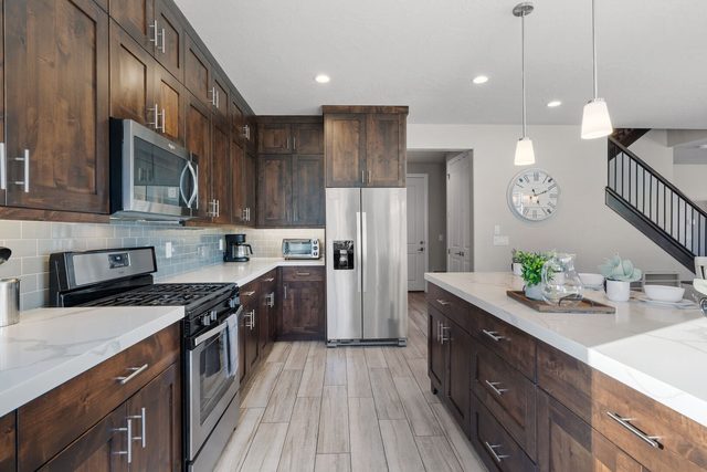 Unit 104 kitchen with gas range, island and wood cabinets