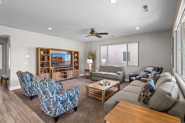 Unit 104 living room with sofas, armchairs and TV cabinet