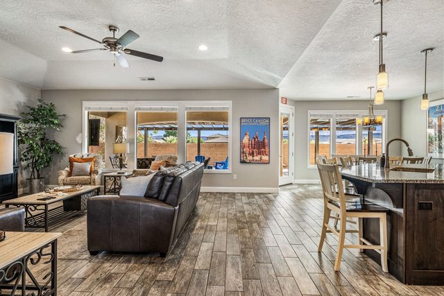 Family room with leather sofa, ceiling fan and kitchen view