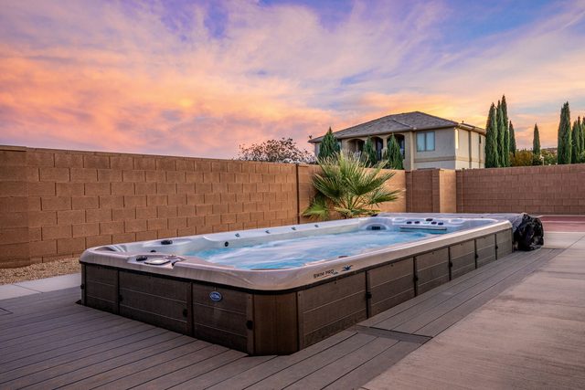 Private swim spa on the deck under a sunset sky