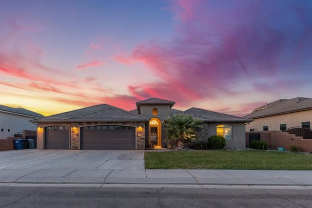 Single-story front exterior and garages of Sand Hollow 3334 at sunset