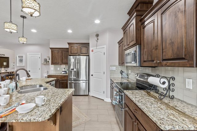 Kitchen with granite counters, stainless range and refrigerator