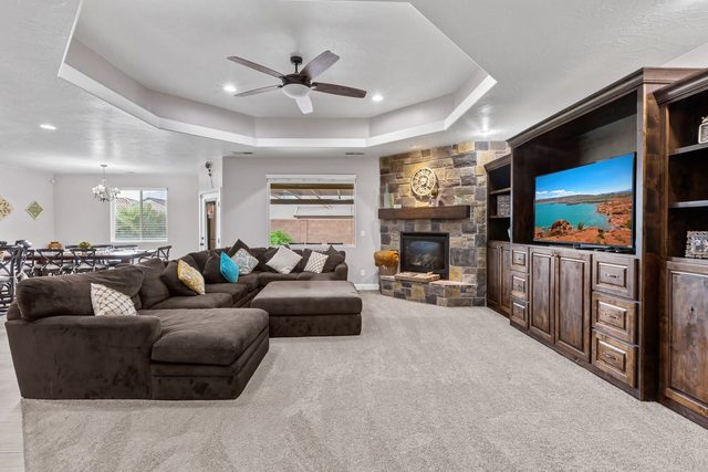 Living room with large sectional, stone fireplace and TV
