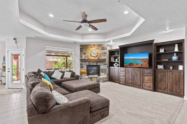 Living room sectional facing stone fireplace and built-in TV cabinet