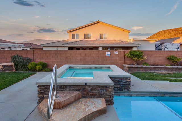 Raised private hot tub spilling into the pool