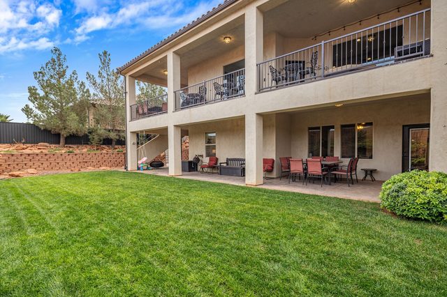 Rear exterior with two-level covered decks above the lawn