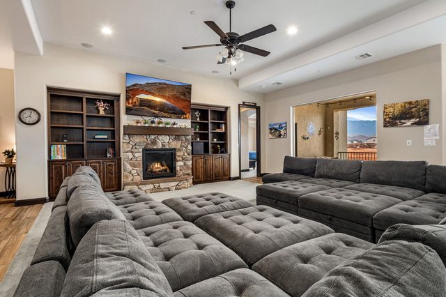 Family room with oversized sectional, stone fireplace and TV