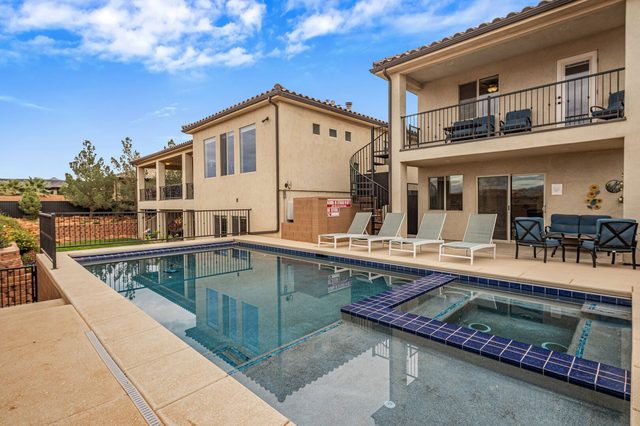 Private pool and spa with lounge chairs behind the home