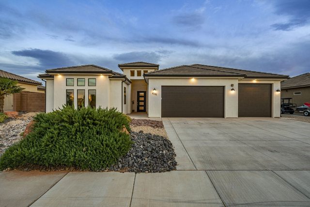 Front exterior with garage doors and driveway at dusk at Sand Hollow 4301