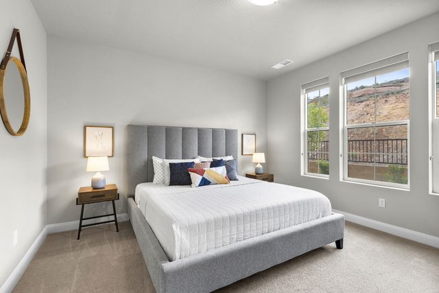 Master bedroom with gray upholstered king bed in home 2311