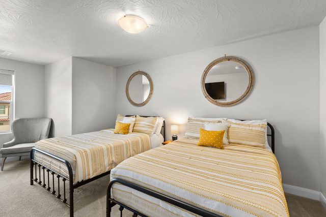 Bedroom with two queen beds and round mirrors in home 2311