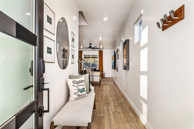 Entry hallway with bench, wood floors and golf-themed decor