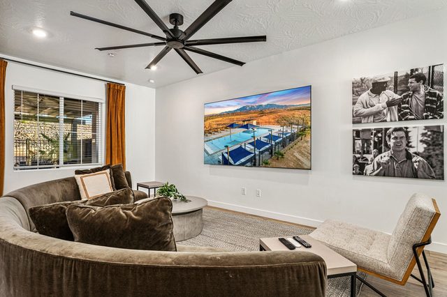 Living room sectional with wall TV, accent chair and ceiling fan
