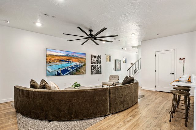 Living room sectional near stairs and kitchen bar stools