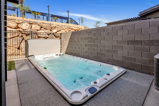 Private swim spa set into backyard patio with block wall
