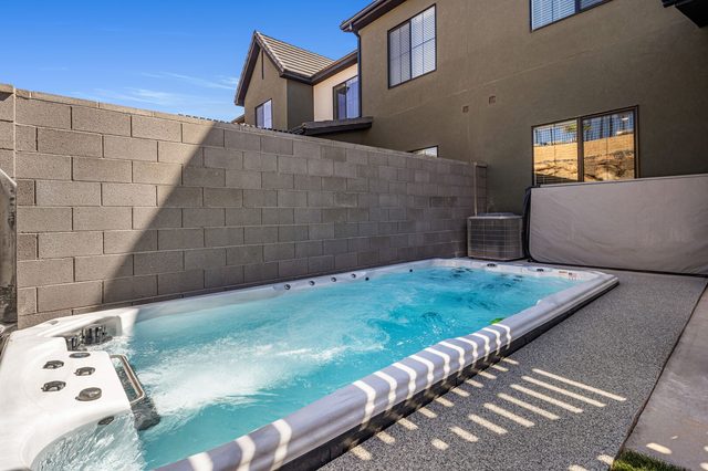 Jetted swim spa with clear water behind the home