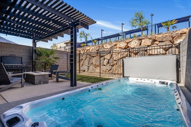 Swim spa with jets running under pergola and blue sky