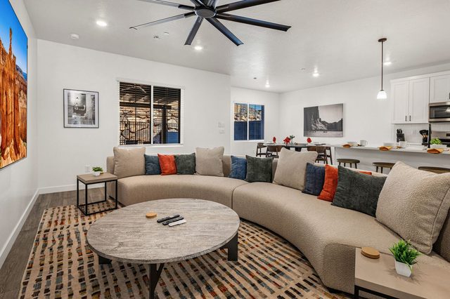 Curved sectional with colorful pillows around a round coffee table
