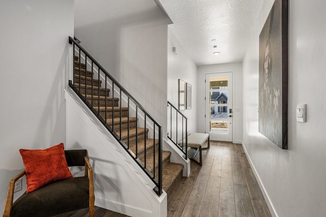 Entry hallway with staircase, accent chair and front door