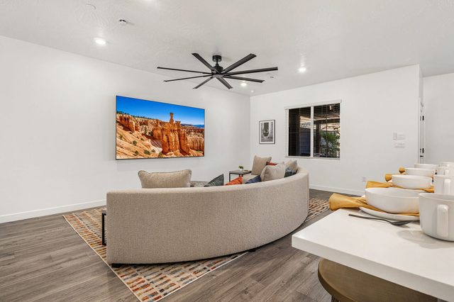 Living room sectional facing large wall TV with red rock image