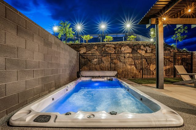 Lit swim spa at night with string lights overhead