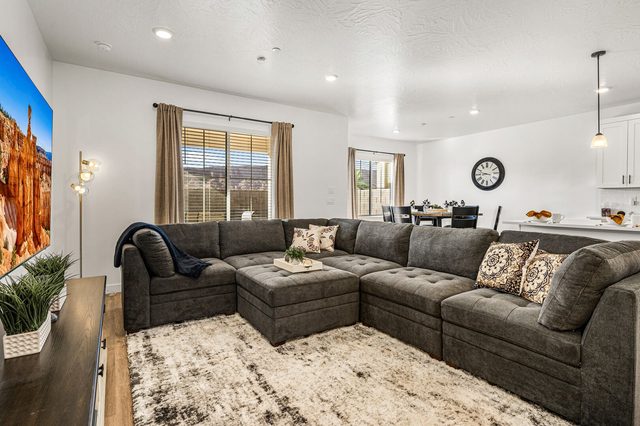 Oversized gray sectional sofa with dining area in the background