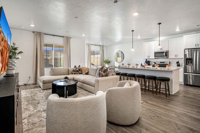 Open living room with sectional and kitchen island at Skyline 1649