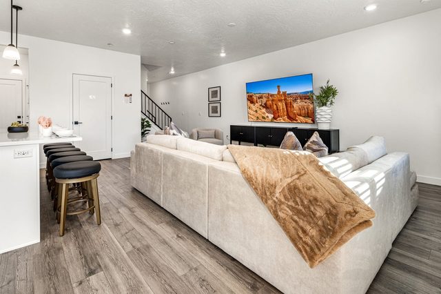 Sectional sofa with bar stools and staircase beyond at Skyline 1649